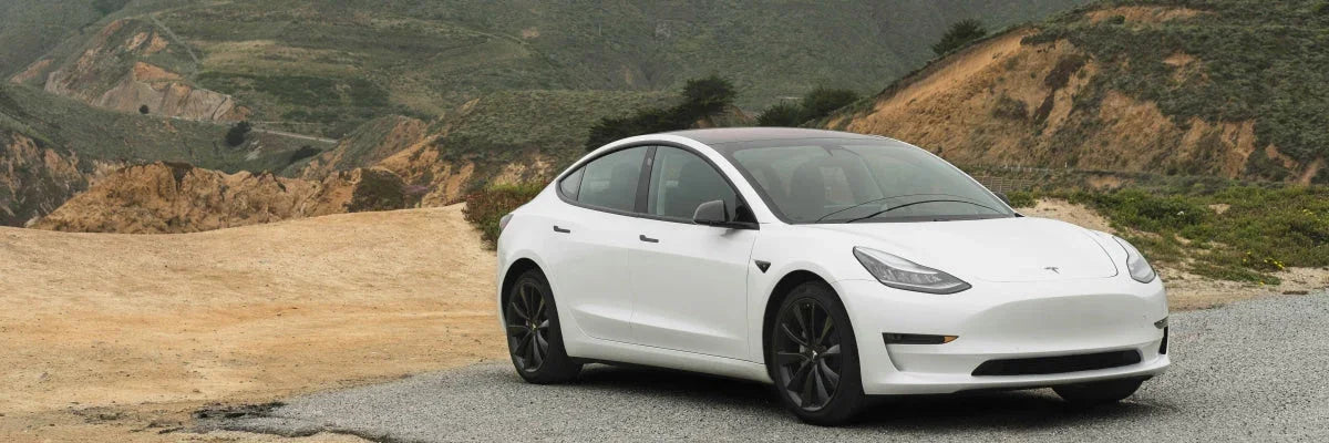 An electric vehicle parked outdoors with a depleted battery, highlighting off-grid charging challenges.
